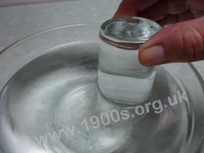 Glass of water upside down in a bowl of water, supported by air pressure
