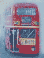 1940s and 50s red double decker London bus with no doors and a pole to grab onto while climbing onto the bus.
