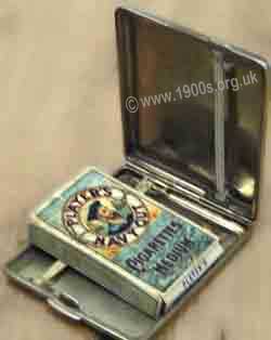 Silver or silver-plated man's cigarette case, common in the mid-1900s, showing the elastic which held the cigarettes in place