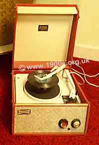 UK 1950s record play with an extended play record ready to drop onto the turntable; in practice there would have been several such records piled on top of one another.