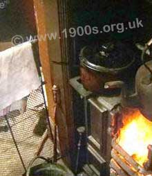 Damp clothes hanging over a fireguard to dry from the heat of the kitchen range