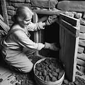 woman prepares for a delivery of coal in the house coal-hole