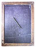 Lined side of a double-sided child's drawing slate from the early 
   1900s; also a slate pencil