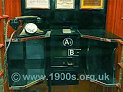 Inside a 1940s / 1950s UK public phone box showing the arrangement of the telephone, the coin slots, button A and button B.