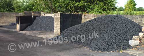 Heaps of various types and grades of coal stored in a coal yard.