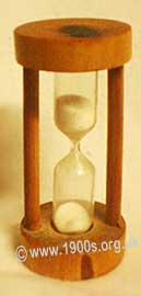 Early egg timer (hour glass type) of sand in glass, set in wood, common before the digital revolution