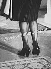 Fully fashioned nylon stockings with seams, worn by a woman in the mid 20th century.