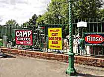 Station platform on the Watercress (Heritage) Line showing old enamelised adverts on the fence