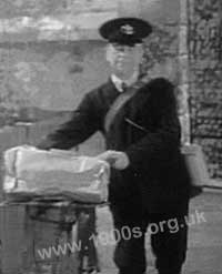 Postman, 1940s or 1950s Britain arriving for a delivery by bicycle.