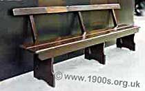 1940s or 1950s British railway station bench seat with a back, wooden