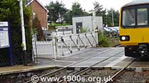 Old-style manual level crossing closed for road traffic and open for trains, thumbnail