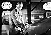 Petrol attendant at a petrol station filling a customer's car with petrol, 1950s, UK