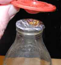 Foil bottle top, dented with a plastic opening gadget known as a denter