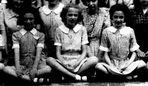 Detail from the 1946 school photo of girls at Copthall County Grammar School, showing the three different colours of the check dresses of the summer uniform.
