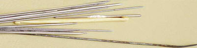 bone crochet hook,tarnished non-stainless steel bodkin, and various knitting needles from the early 1900s
