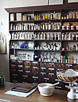 Bottles and storage drawers in a Victorian or Edwardian chemists' shop