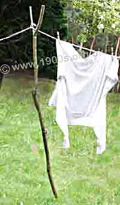 Wooden clothes prop made from a sawn-off branch of a tree, raising the washing line up high to catch the wind.