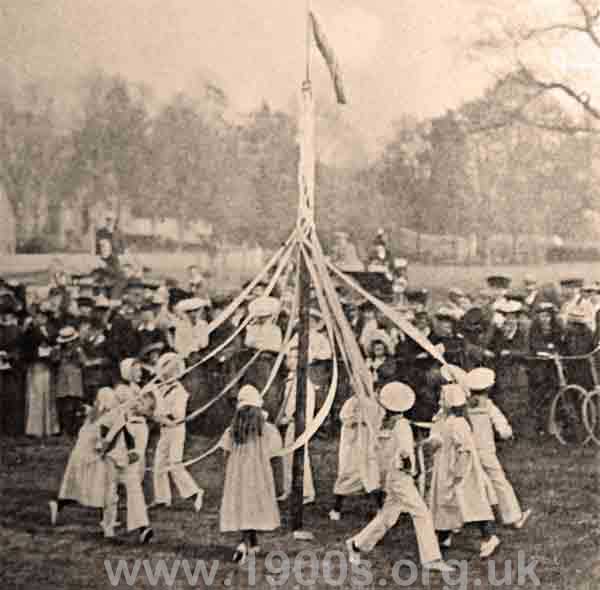 Children in the early 1900s dancing round a maypole on May Day (May 1st).