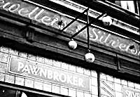 old English pawnbroker's shop showing the name plate, glass front and pawnbroker sign of three gold balls