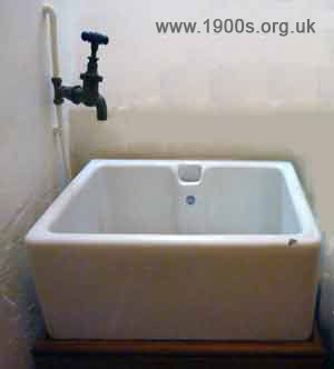 Old stoneware sink with a single brass cold water tap above it