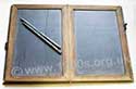 Old folding slate and slate pencils, as used in the
early 1900s for school children to practise writing