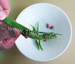 Slicing a runner bean cross ways with a knife