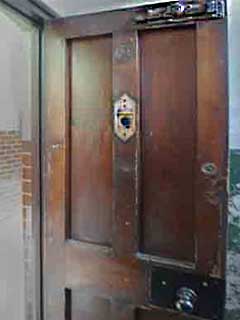 The heavy door to the cell of a casual ward, also known as a dosshouse,
showing the huge bold at the top and the peep hole to let the 'tramp major' keep an eye on the vagrants.
