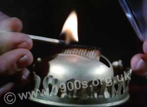 Wick of an oil lamp at the point of being lit with a match