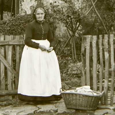 Woman outside with damp washing/laundry, ready to bring it in for ironing