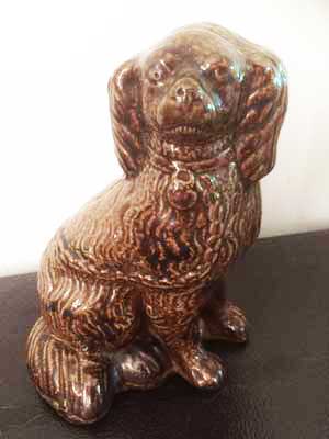 One of a set of three pottery dogs made by William Cox, 1874