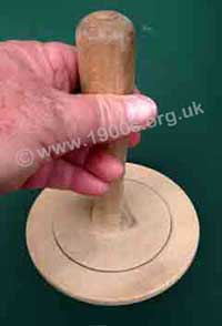 Old wooden plunger to drain cabbage in a colander