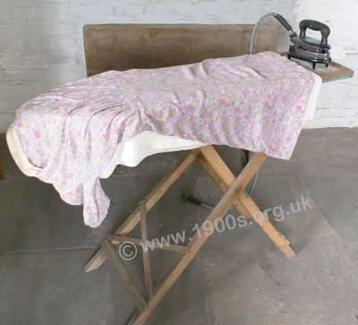 Old ironing board on a wooden frame, as used before plastics and plastic coatings became common place